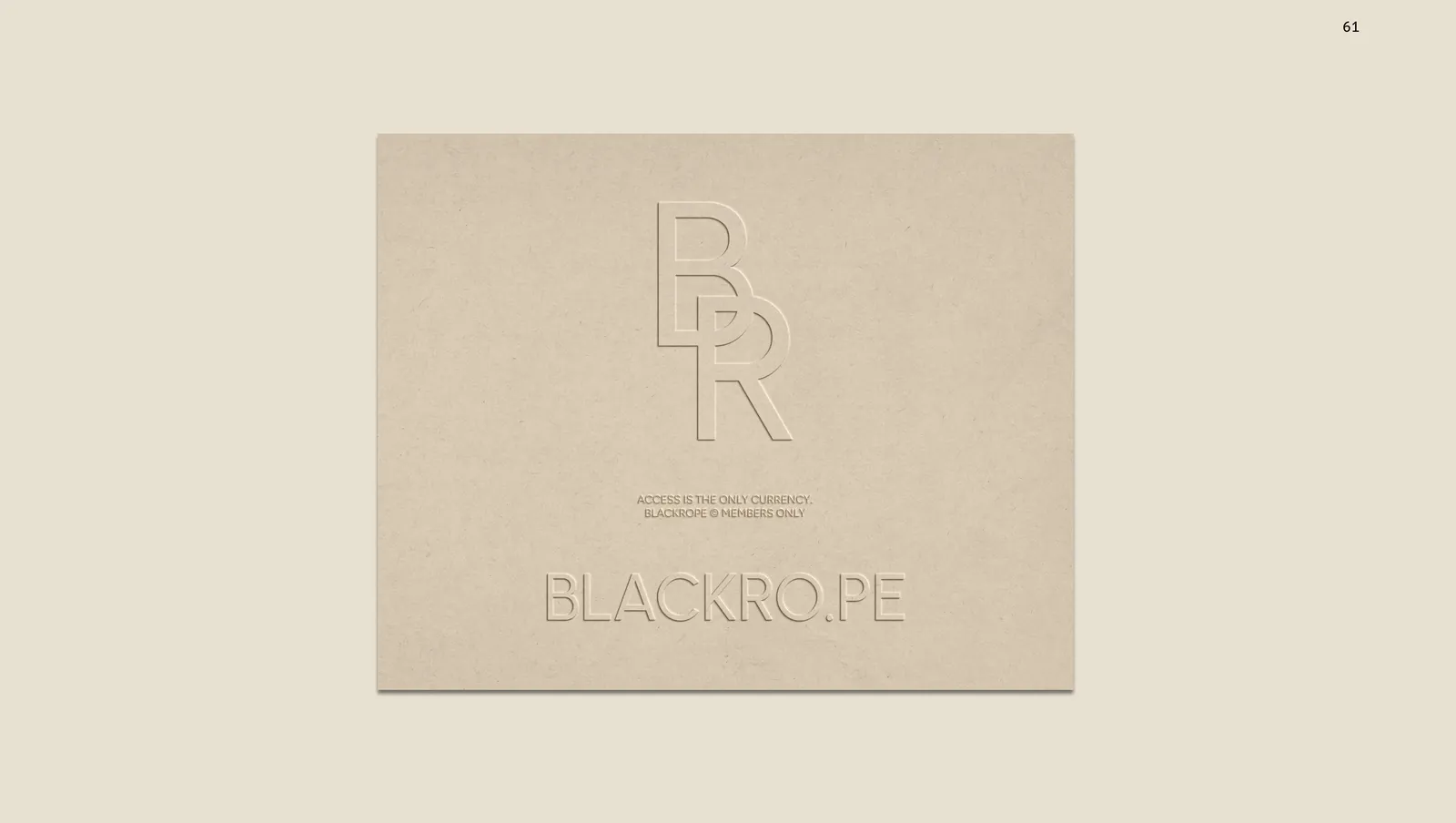 A kraft board with the serif monogram and the wordmark blind embossed into it.