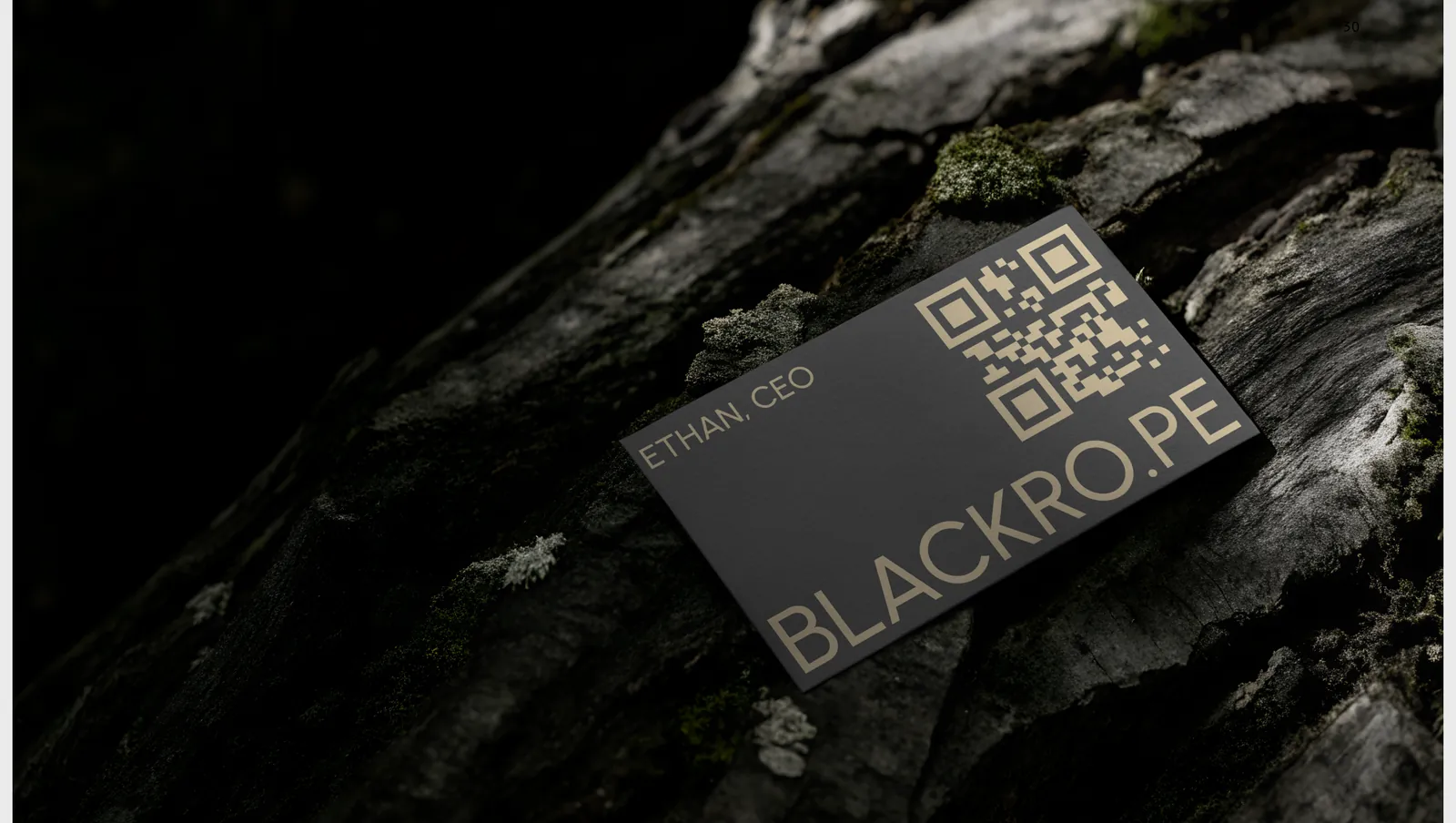 A metal member card resting on rock, "Ethan, CEO" beside the wordmark and a QR code.