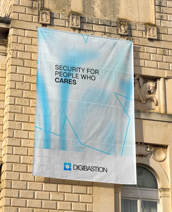 A Digibastion banner hung on a brick facade, reading “security for people who cares”