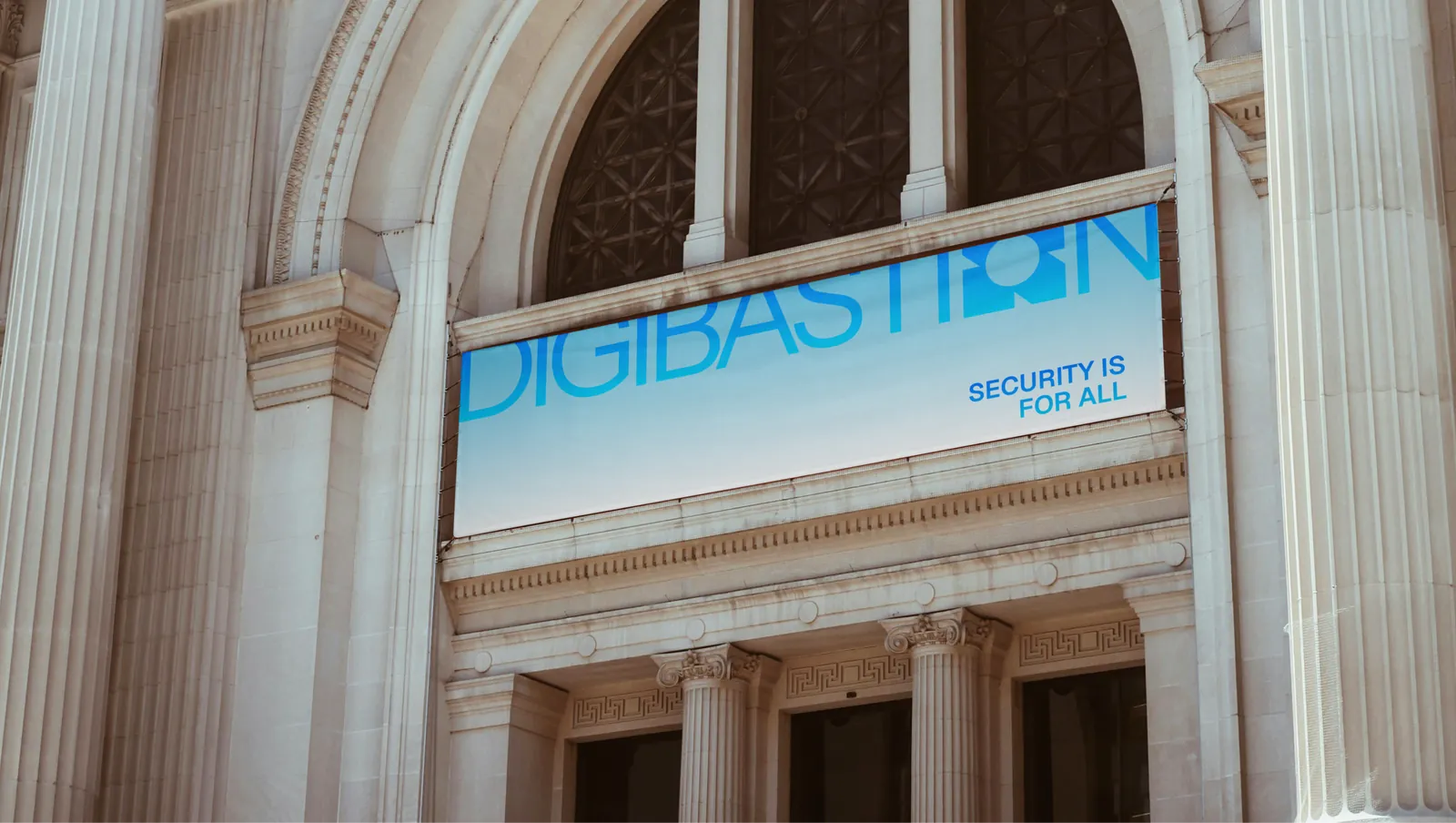 A Digibastion banner strung across a neoclassical facade, reading "Security is for all".